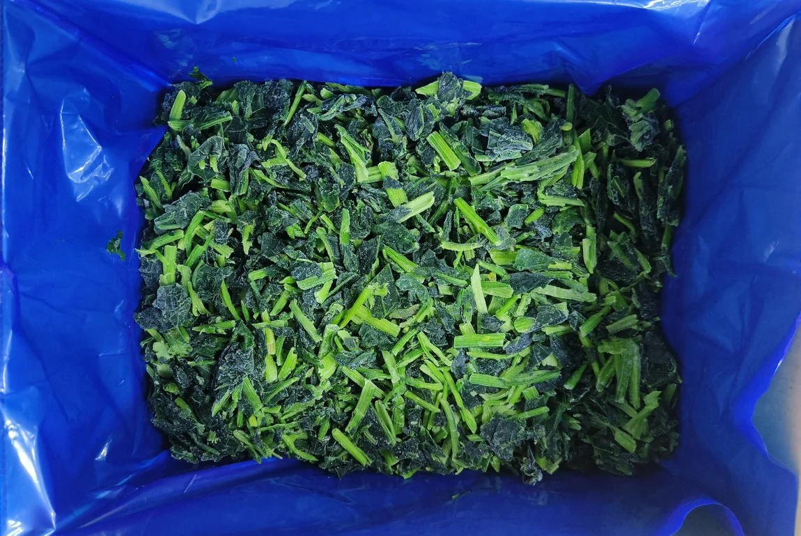 Identify the actual cut spinach in the starting sample Loose frozen cut spinach leaves and stems inside a plain blue liner, showing the material to identify before a preparation trial