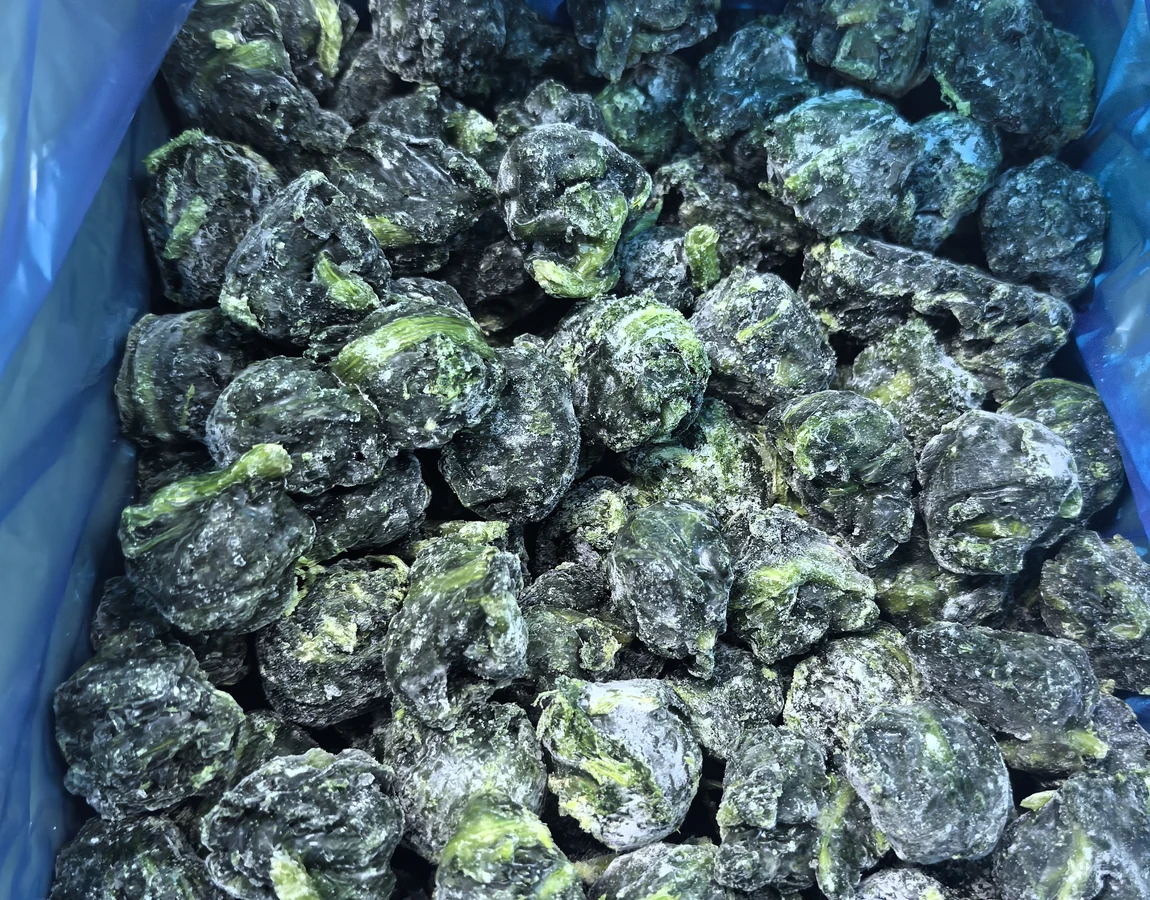 Check portion mass and separability in the actual pack Compact frosted spinach portions in a plain blue liner showing individual unit shapes before weighing and dosing checks