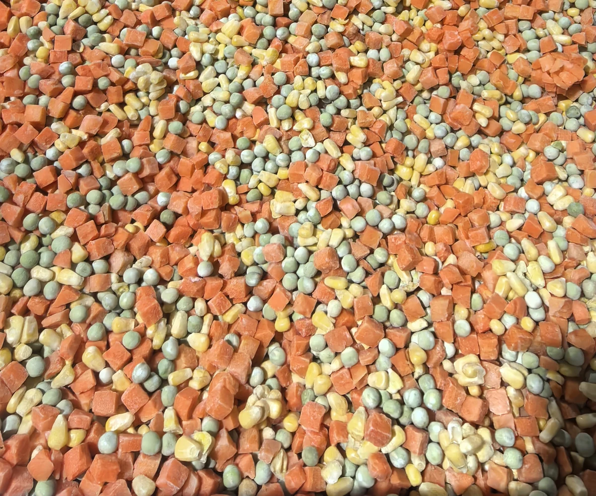 Identify the material represented by the pea report Round green peas mixed with diced carrots and sweet corn on a plain tray