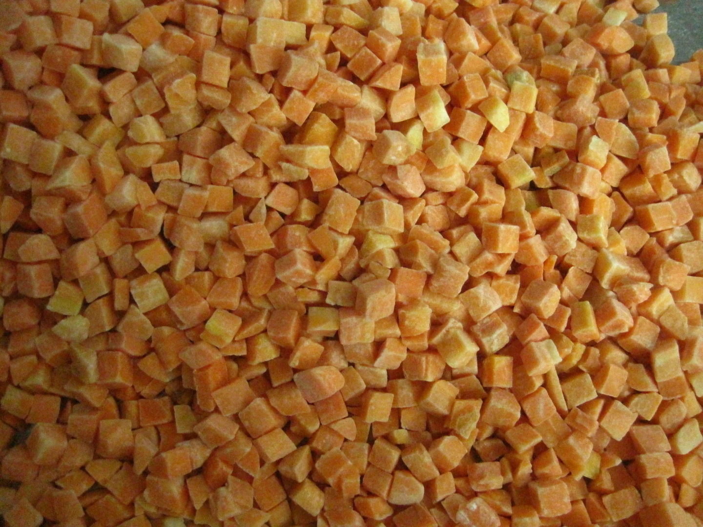 Original close view of frozen carrot dice and small fragments