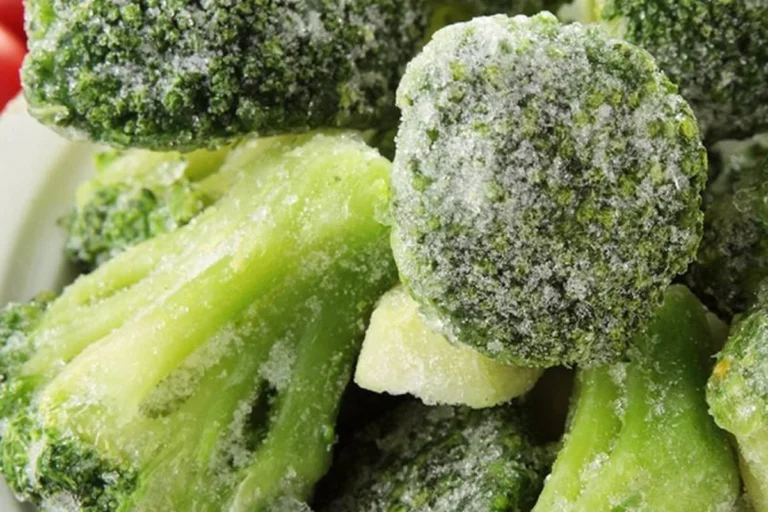 Frosted broccoli crowns with attached pale stems before soup preparation