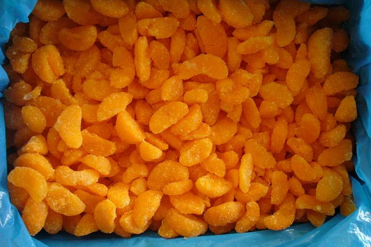 Identify the mandarin ingredient form Orange mandarin segments in a blue-lined container showing their crescent form