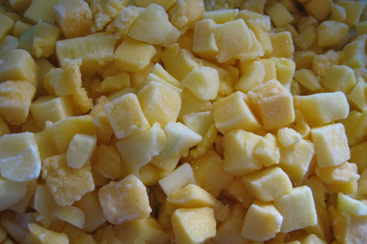Dados de mango congelado antes de emplatar con arroz glutinoso Dados de mango con escarcha, bordes y tamaños de corte variados