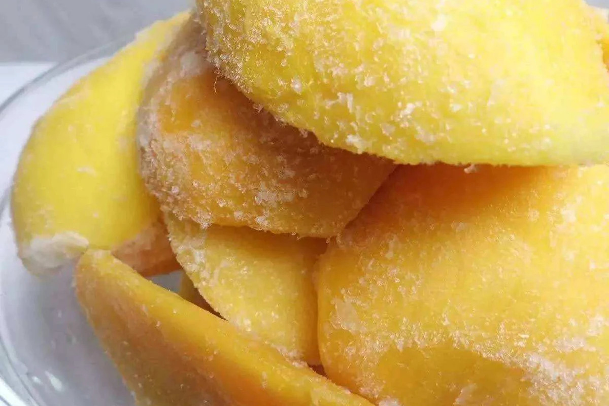 Larger frozen mango pieces for sauce trials Large frosted mango pieces stacked in a clear dish