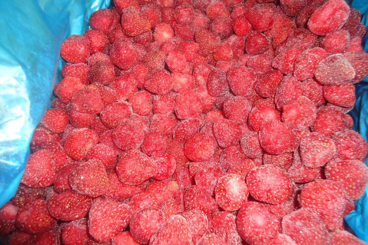 Fresas congeladas enteras muestran el tamaño de fruta antes de descomponer una salsa para marmolado