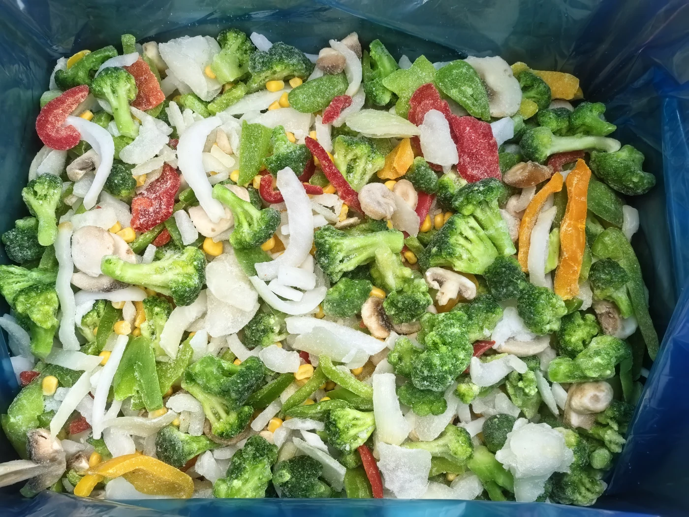 Vegetable mix in a liner Mixed broccoli pepper onion corn and mushroom pieces in a blue liner