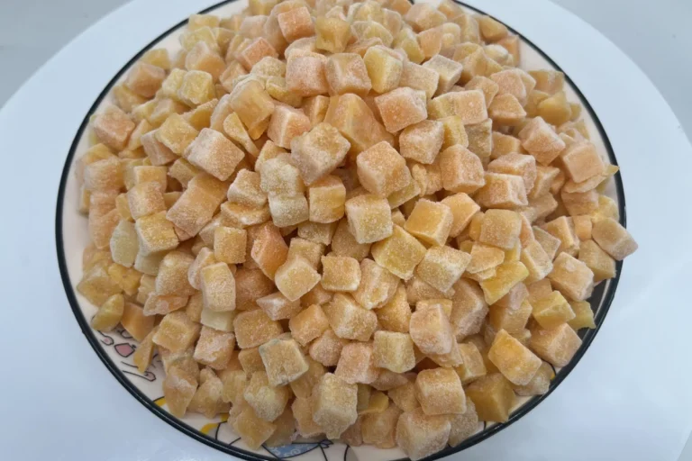 Cubos de boniato con escarcha amontonados sobre un plato blanco