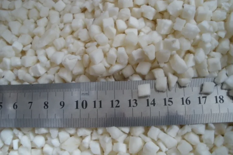 Frozen diced water chestnut pieces beside a metal size ruler