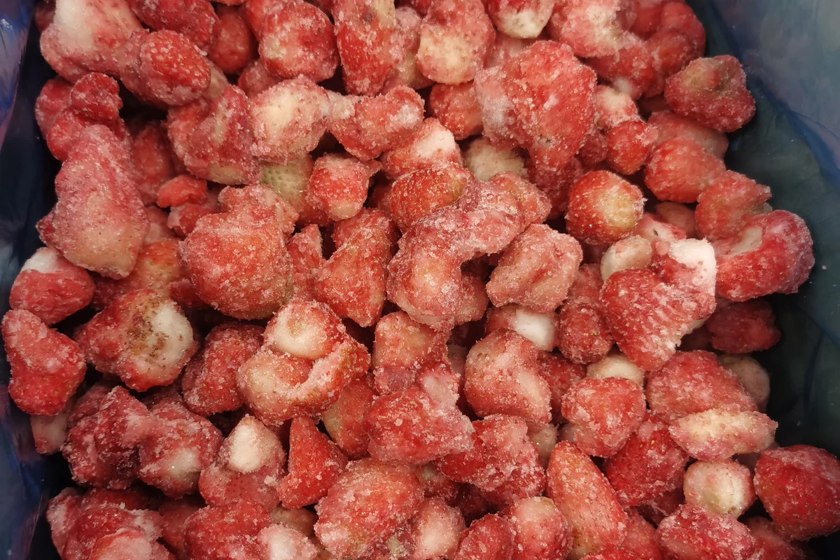 Frozen strawberry chunks in a dark liner showing a cut form whose process inputs need confirmation